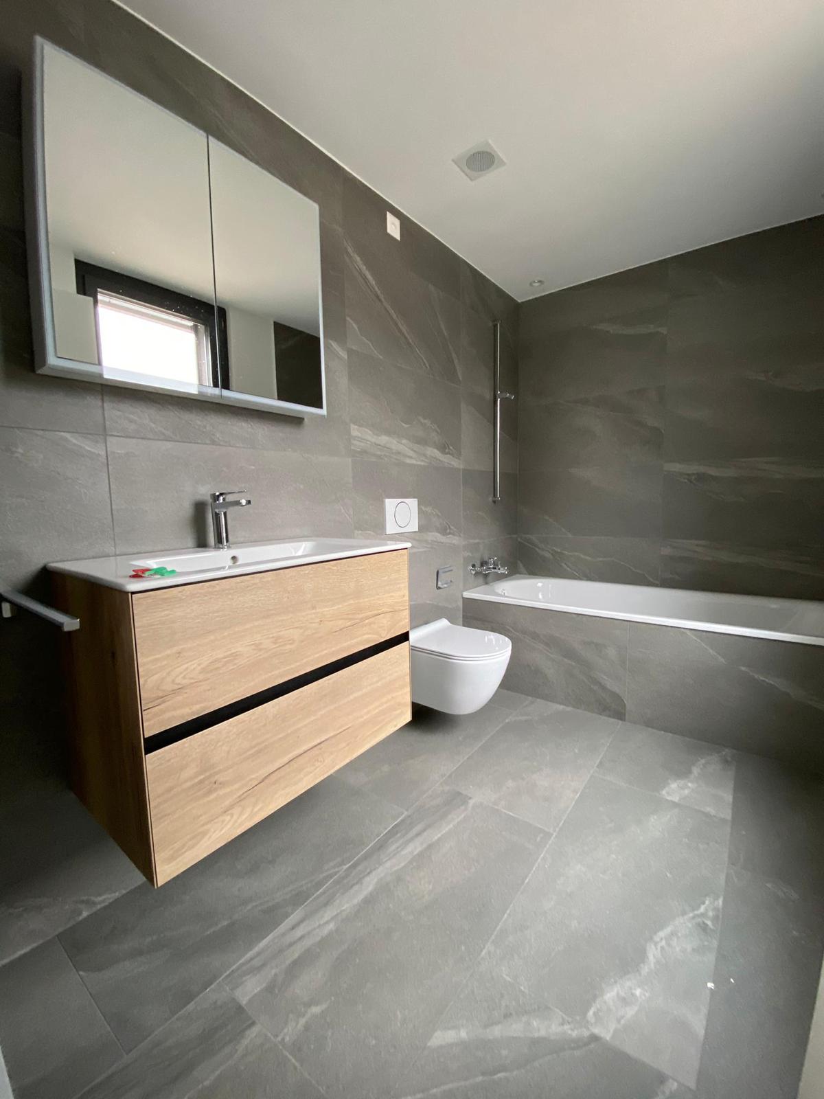 Badezimmer mit grauen Platten in Marmoroptik